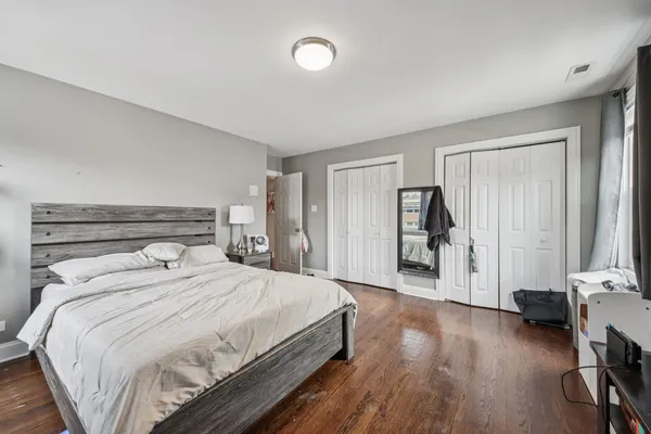 a bedroom with a bed and wooden floor