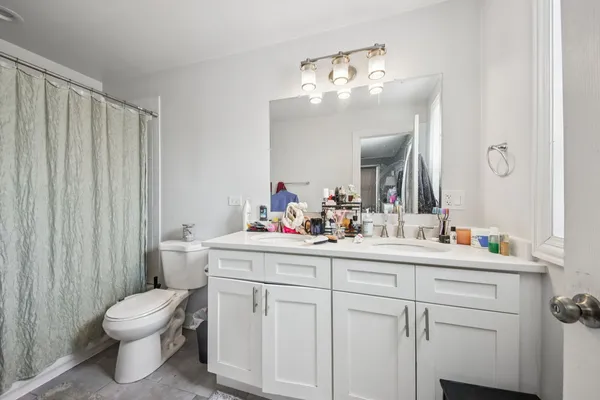 a bathroom with a toilet a sink and mirror