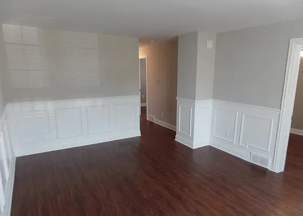 a view of an empty room with wooden floor