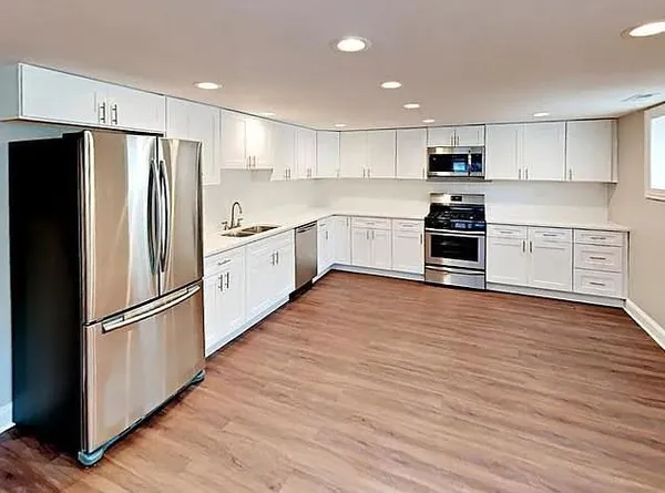 a kitchen with stainless steel appliances a refrigerator sink and wooden floor