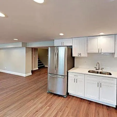 a kitchen with wooden floors and stainless steel appliances