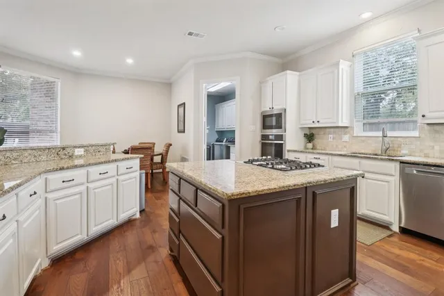 a kitchen with granite countertop sink stove and cabinets
