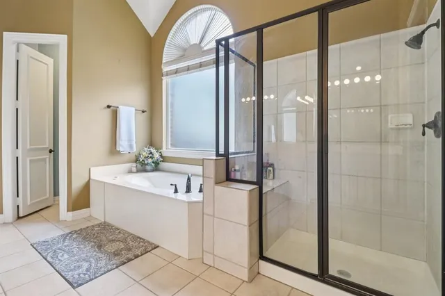 a bathroom with a tub sink shower and mirror