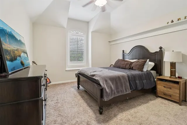 a bedroom with a bed and a flat tv screen on dresser