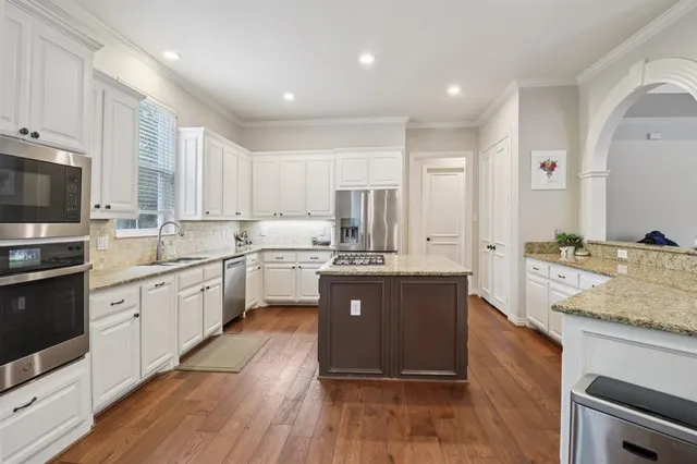 a large kitchen with stainless steel appliances sink a microwave and cabinets