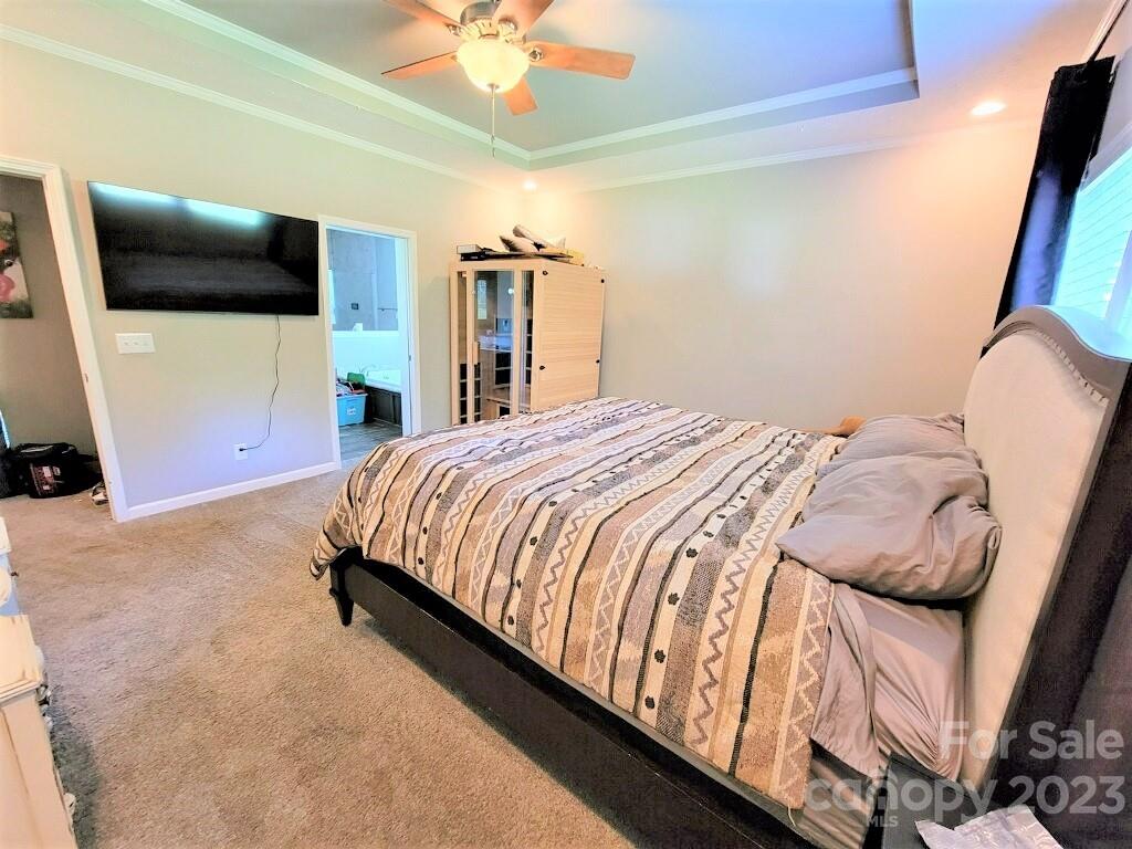 3230 Sorrells Baxter Road Cherryville, NC 28021 - Photo 15 of 29 a bedroom with a bed a flat screen tv and a chandelier