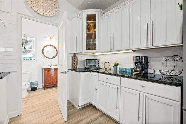 a kitchen with stainless steel appliances granite countertop a sink and cabinets with wooden floor
