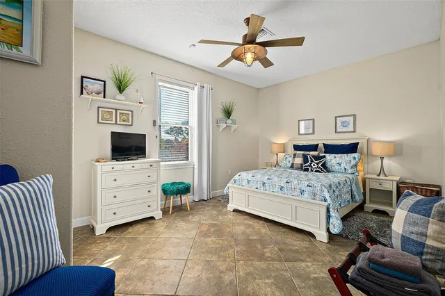 a spacious bedroom with a bed and a flat screen tv