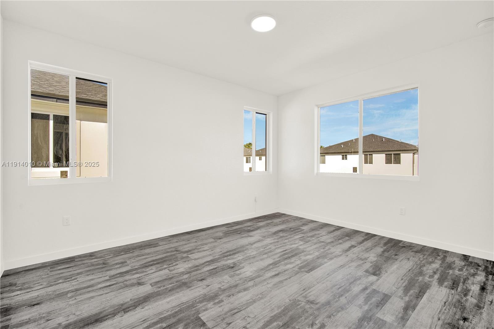 22535 Southwest 125th Avenue, Unit 22535 Miami, FL 33170 - Photo 22 of 35 an empty room with wooden floor and windows