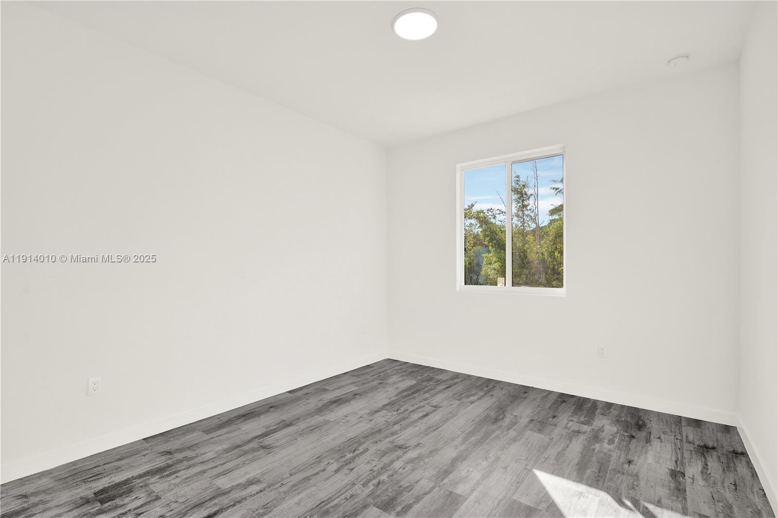 22535 Southwest 125th Avenue, Unit 22535 Miami, FL 33170 - Photo 30 of 35 a view of an empty room with wooden floor and a window