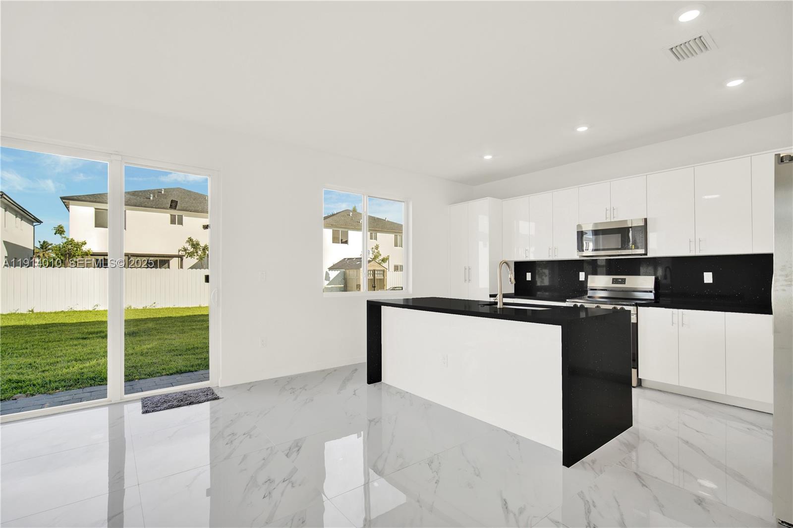 22535 Southwest 125th Avenue, Unit 22535 Miami, FL 33170 - Photo 10 of 35 a kitchen with stainless steel appliances kitchen island granite countertop a refrigerator and a sink