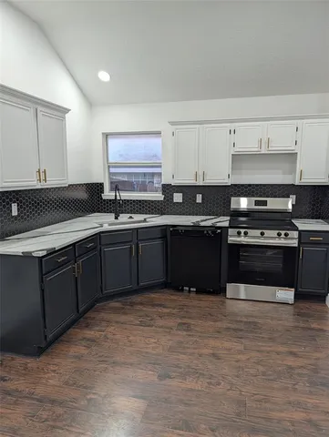 a kitchen with stainless steel appliances granite countertop a stove a sink and a microwave