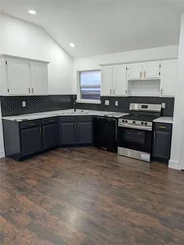 a large kitchen with stainless steel appliances granite countertop a stove and a sink