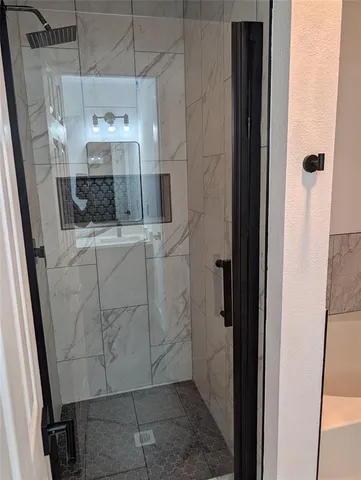a bathroom with a shower and mirror