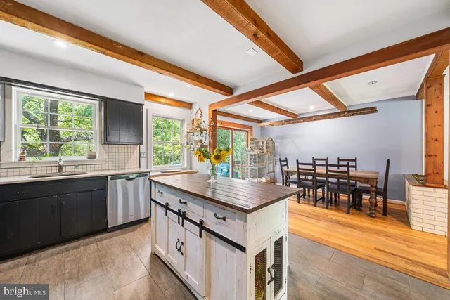 a kitchen with a stove a sink and a dining table view