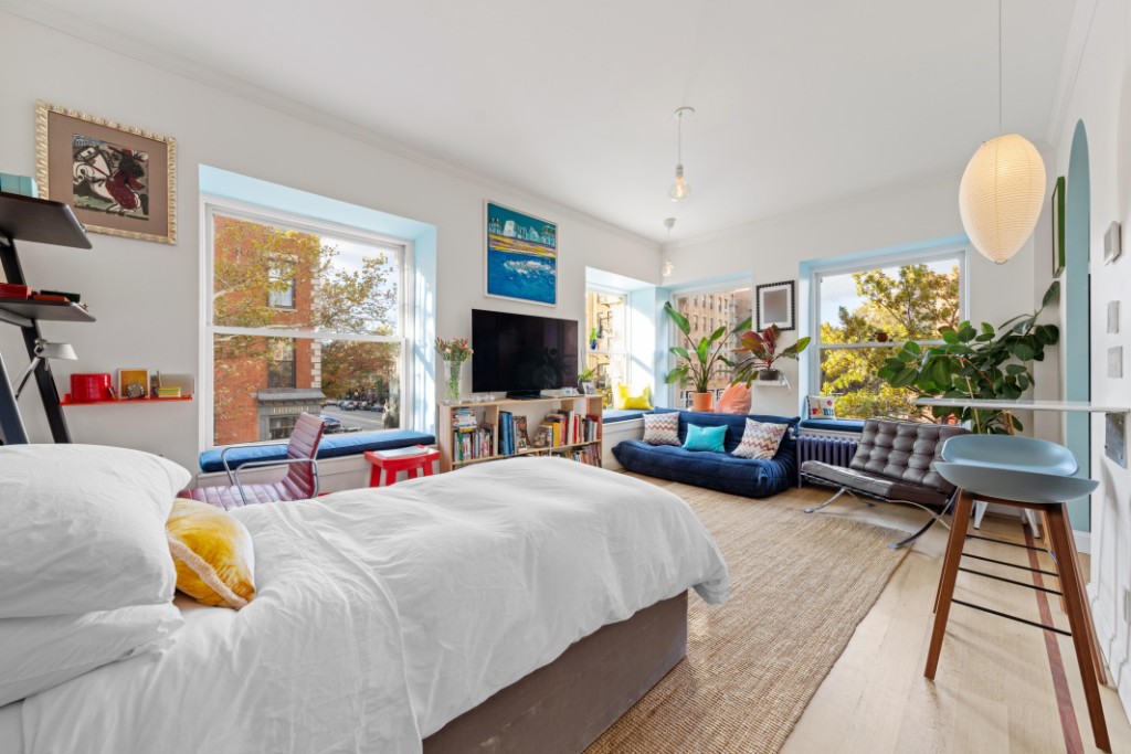 191 Clinton Street, Unit 2D Brooklyn, NY 11201 - Photo 1 of 30 a bedroom with a bed and a flat tv screen next to a large window