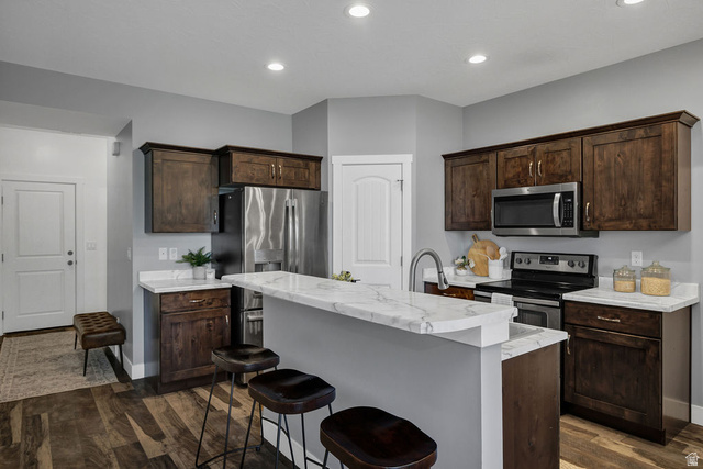 2483 South 1296th Street West Logan, UT 84321 - Photo 8 of 45 Kitchen featuring dark wood cabinetry, white stone-finish countertops, and stainless steel appliances