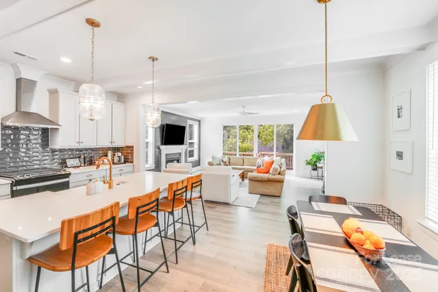 a dining room with furniture a chandelier and wooden floor