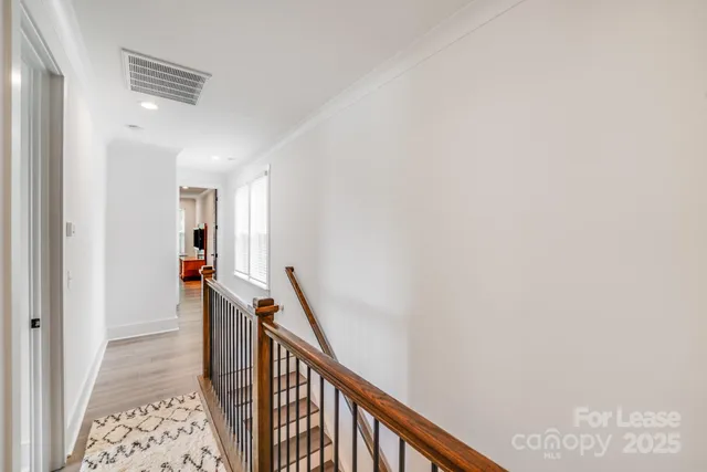 a view of a hallway with wooden floor and entryway
