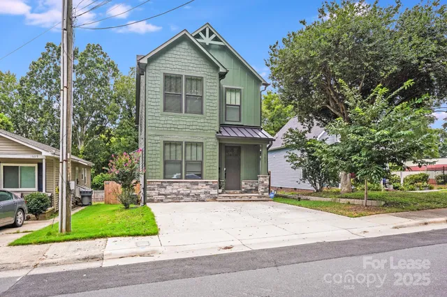 a front view of a house with a garden and plants