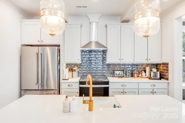 a kitchen with stainless steel appliances kitchen island granite countertop a white sink and cabinets