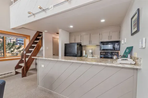 a kitchen with stainless steel appliances granite countertop sink refrigerator and microwave