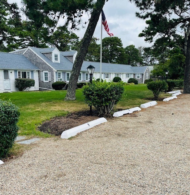 75 Beaten Road, Unit 12 Dennis, MA 02639 - Photo 2 of 26 a front view of a house with a yard and potted plants