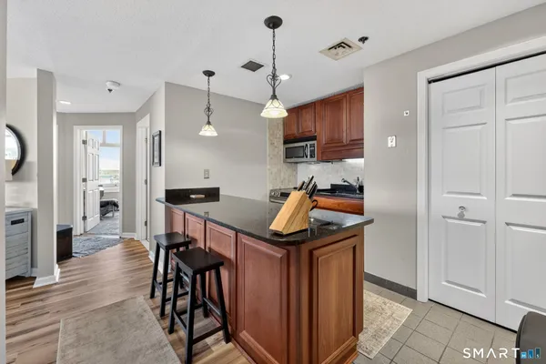 a kitchen that has a kitchen island a sink stainless steel appliances and cabinets