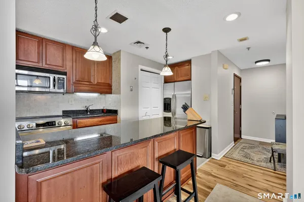 a kitchen with stainless steel appliances granite countertop a stove a sink and a refrigerator