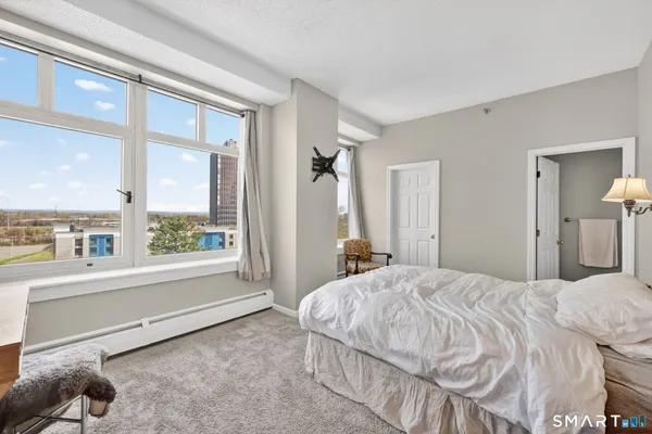 a bedroom with a bed and a large window with outer view