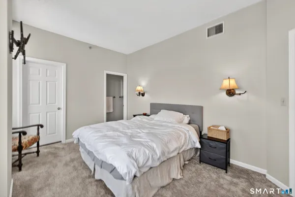a bedroom with a bed and a lamp