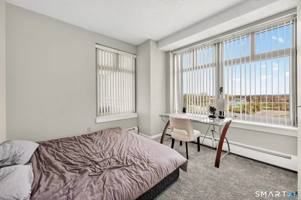 a bedroom with a bed and a large window