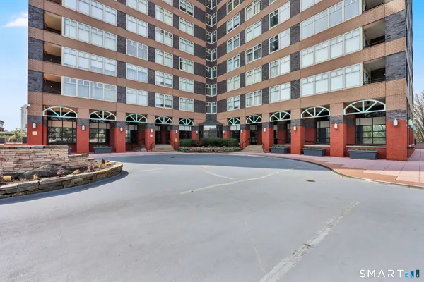a front view of multi story residential apartment building with retail shops