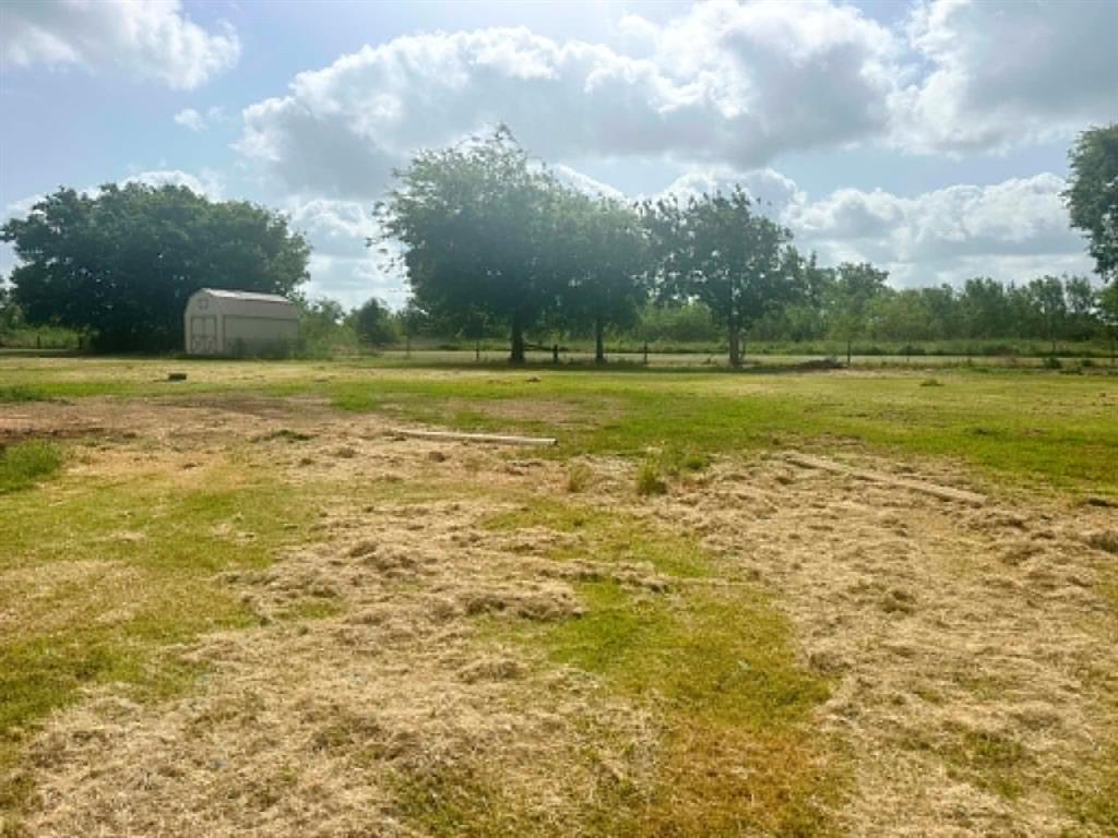 1275 John Wayne Road Kaufman, TX 75142 - Photo 4 of 11 Expansive lot featuring a metal storage shed, mature trees, and a partially mowed grassy area