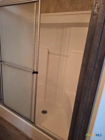 a bathroom with a glass shower door