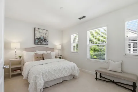 a bedroom with a bed and a couch next to a window