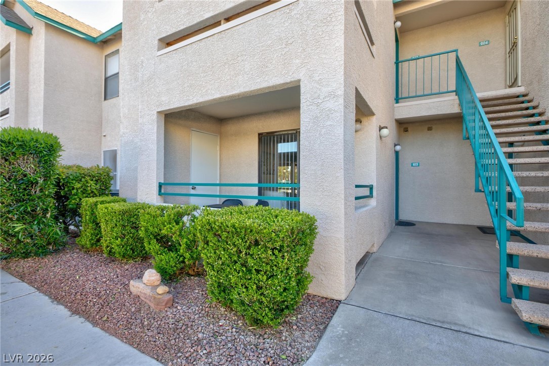 5171 South Lindell Road, Unit 103 Las Vegas, NV 89118 - Photo 3 of 24 A private entry patio invites relaxation, surrounded by meticulously maintained landscaping and accessible via an external staircase.