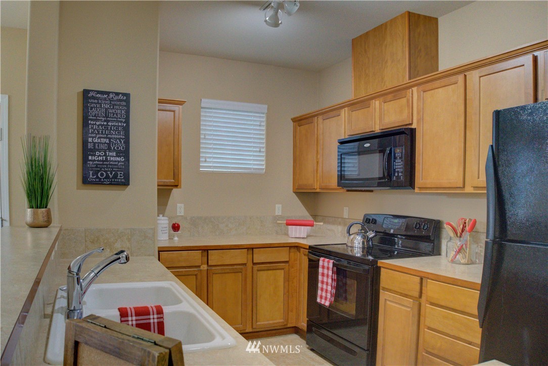 14915 38th Drive Southeast, Unit EE2029 Bothell, WA 98012 - Photo 6 of 12 a kitchen with a refrigerator and a stove top oven