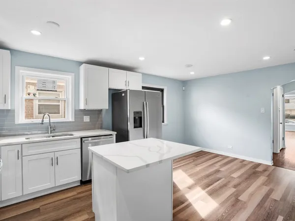 a large kitchen with a sink and refrigerator
