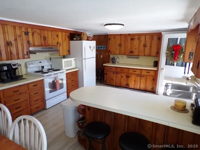 a kitchen with stainless steel appliances a stove a refrigerator and wooden cabinets
