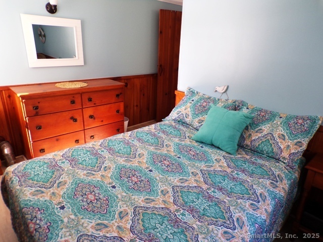 64 Washington Avenue Old Lyme, CT 06371 - Photo 17 of 25 a bedroom with a bed and a flat tv screen on dresser