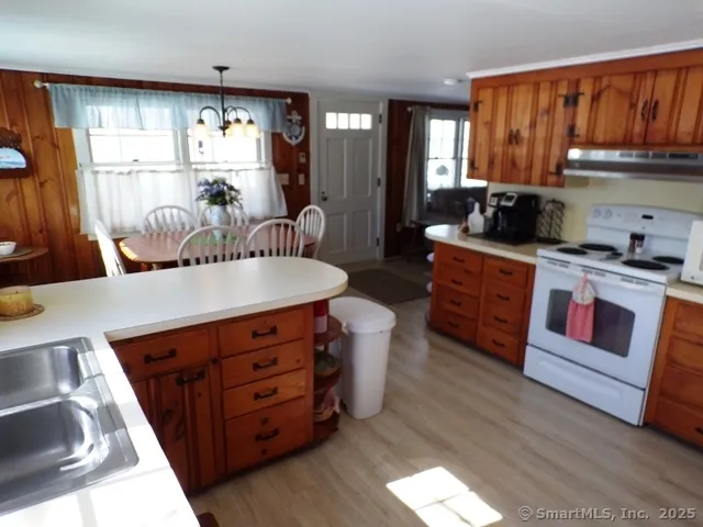 a kitchen with stainless steel appliances granite countertop a stove a sink dishwasher and cabinets with wooden floor