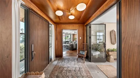 a view of a hallway with bathroom and glass door
