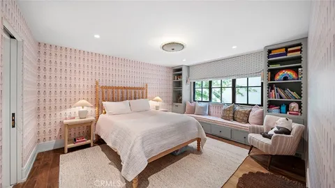a bedroom with a bed furniture and a book shelf
