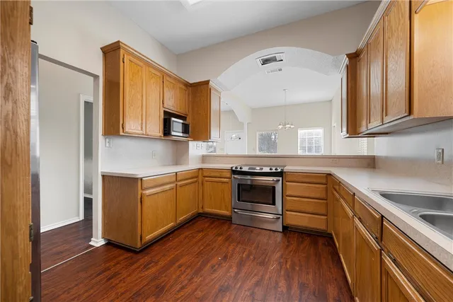 a kitchen with granite countertop a stove top oven and sink