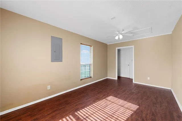 a view of an empty room with window and wooden floor