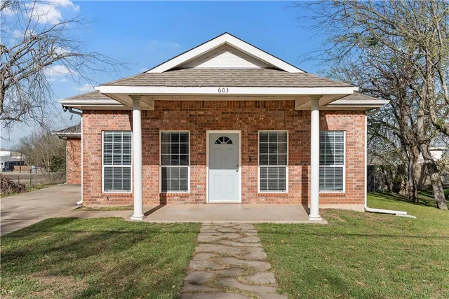 a front view of a house with a garden