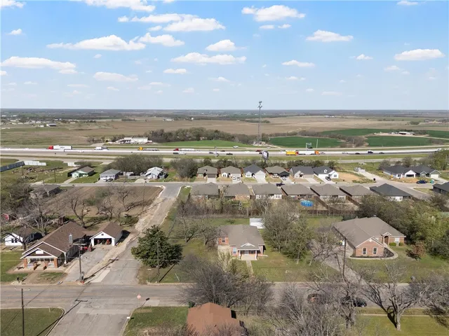 an aerial view of ocean and residential houses with outdoor space