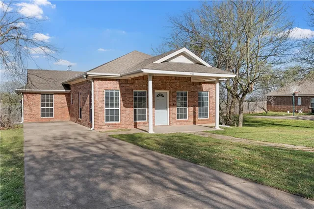 a front view of a house with a garden