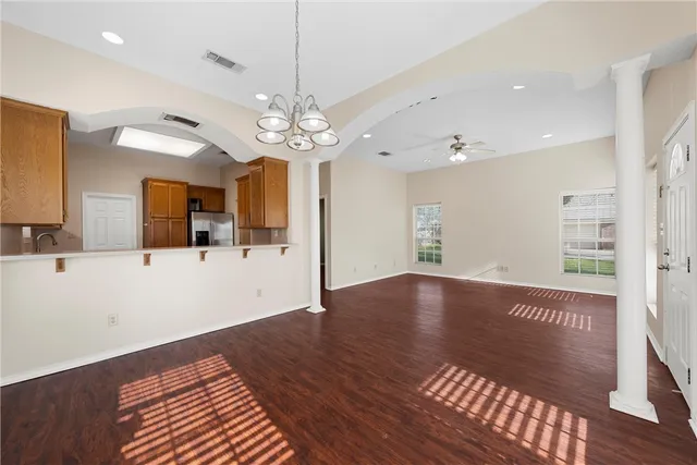 a view of a big room with wooden floor and a kitchen